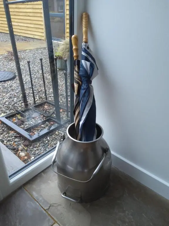 an umbrella in a pot next to a door at Ardachy Riverside Accessible One bedroom Holiday let in Fort Augustus