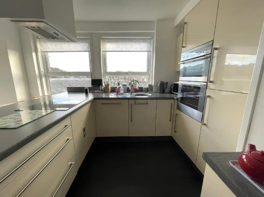 a small kitchen with white cabinets and appliances at Home in Forres, Moray in Forres