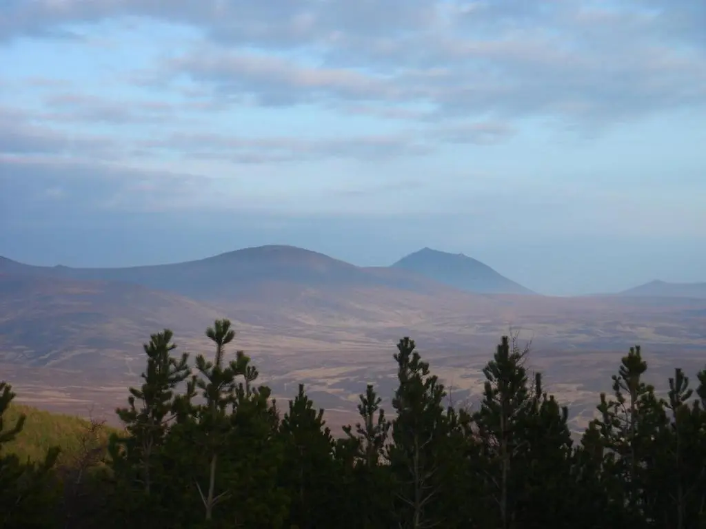 a view of a mountain range with trees in the foreground at Special Offer, Cosy Cottage Near the Sea in Embo in Embo