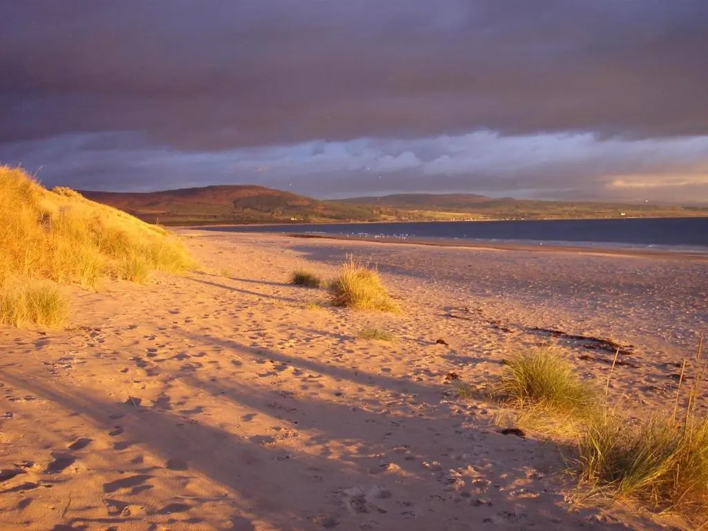 a sandy beach with a cloudy sky and water at Special Offer, Cosy Cottage Near the Sea in Embo in Embo