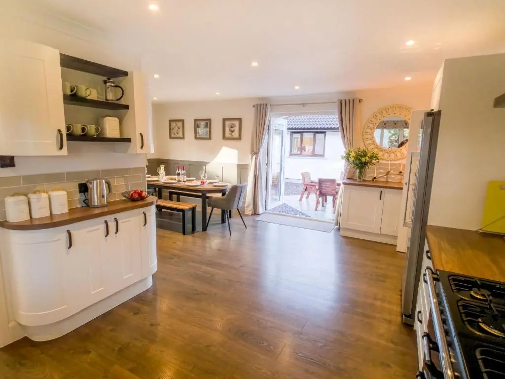 a kitchen and dining room with a table and a counter top at Woodland House in Tomatin