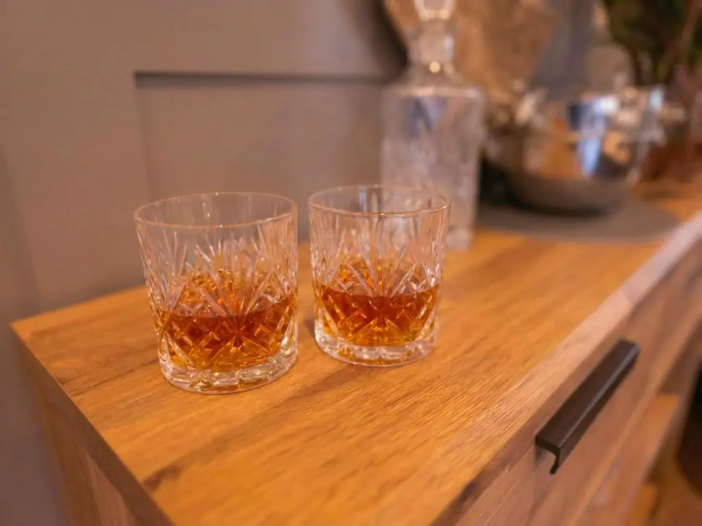 two glasses of tea sitting on a wooden table at Woodland House in Tomatin