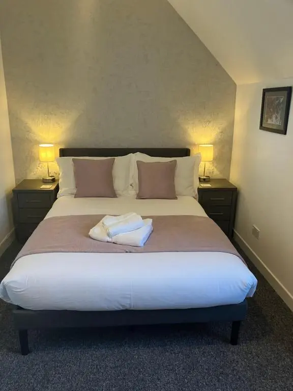 a bedroom with a large bed with two night stands at Toll House in Wick