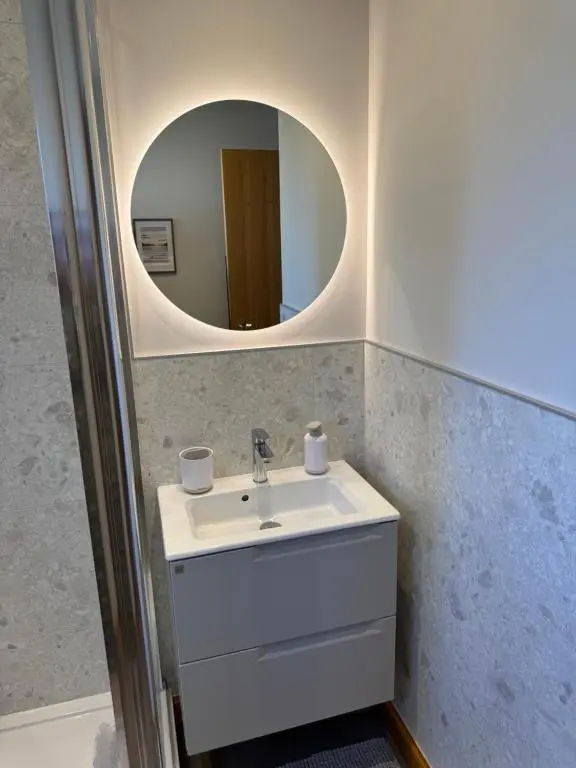 a bathroom with a sink and a mirror at Firth Tides in Nairn