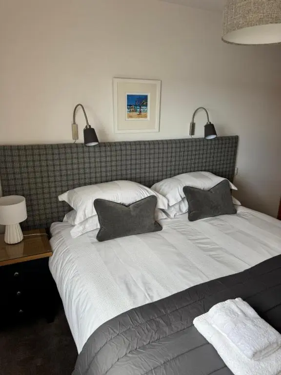 a large white bed with two pillows on it at Firth Tides in Nairn