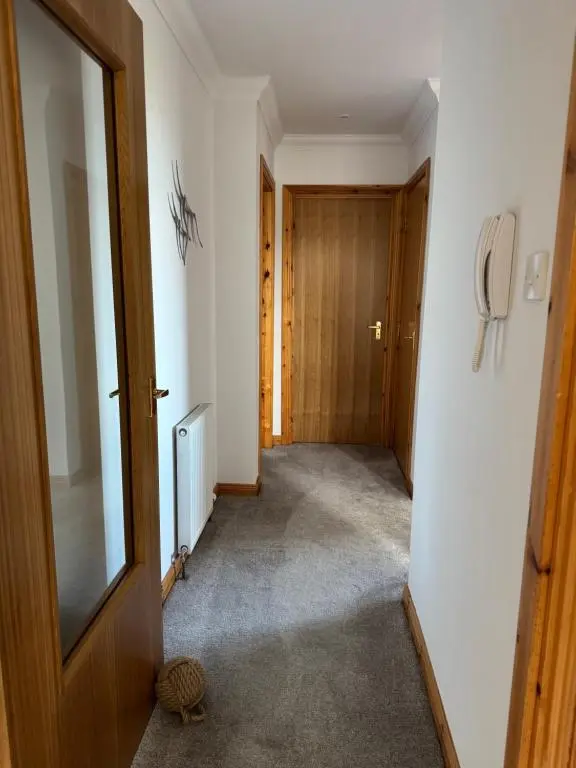 a hallway with a door leading to a room at Firth Tides in Nairn