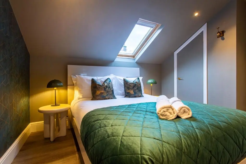 a bedroom with a bed with two towels on it at 17 at the Bell Tower in Inverness