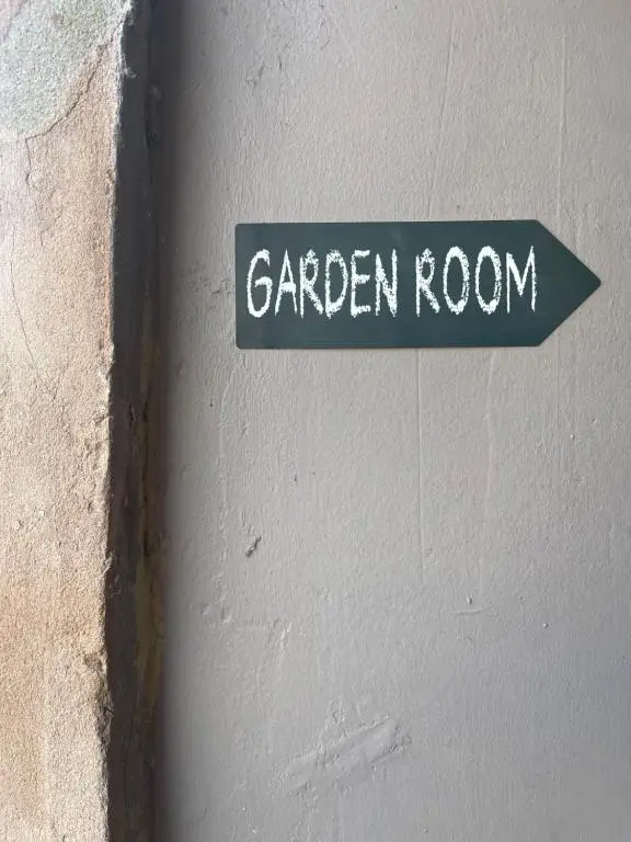a green sign that says garden room on a wall at Garden Room at Tartan House in Inverness
