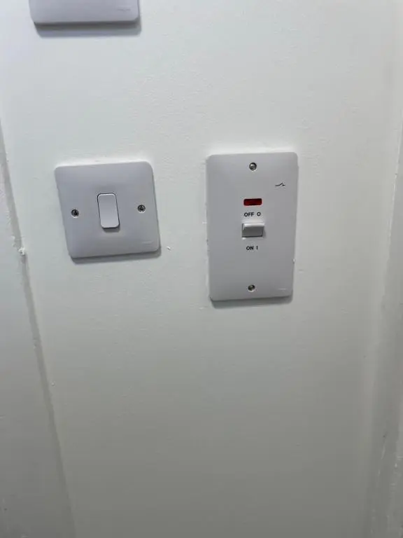 an electrical outlet on the side of a refrigerator at Garden Room at Tartan House in Inverness
