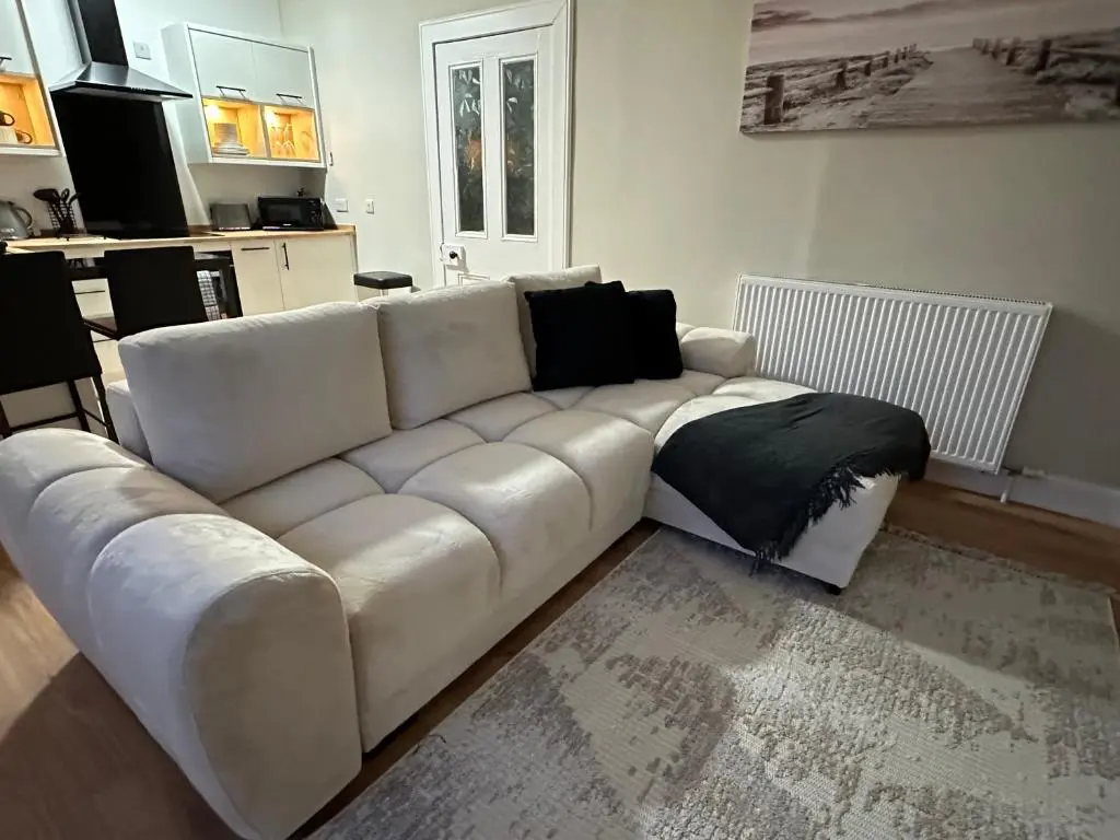 a white leather couch in a living room at The Nairn Neuk - Couples Cosy Getaway in Nairn