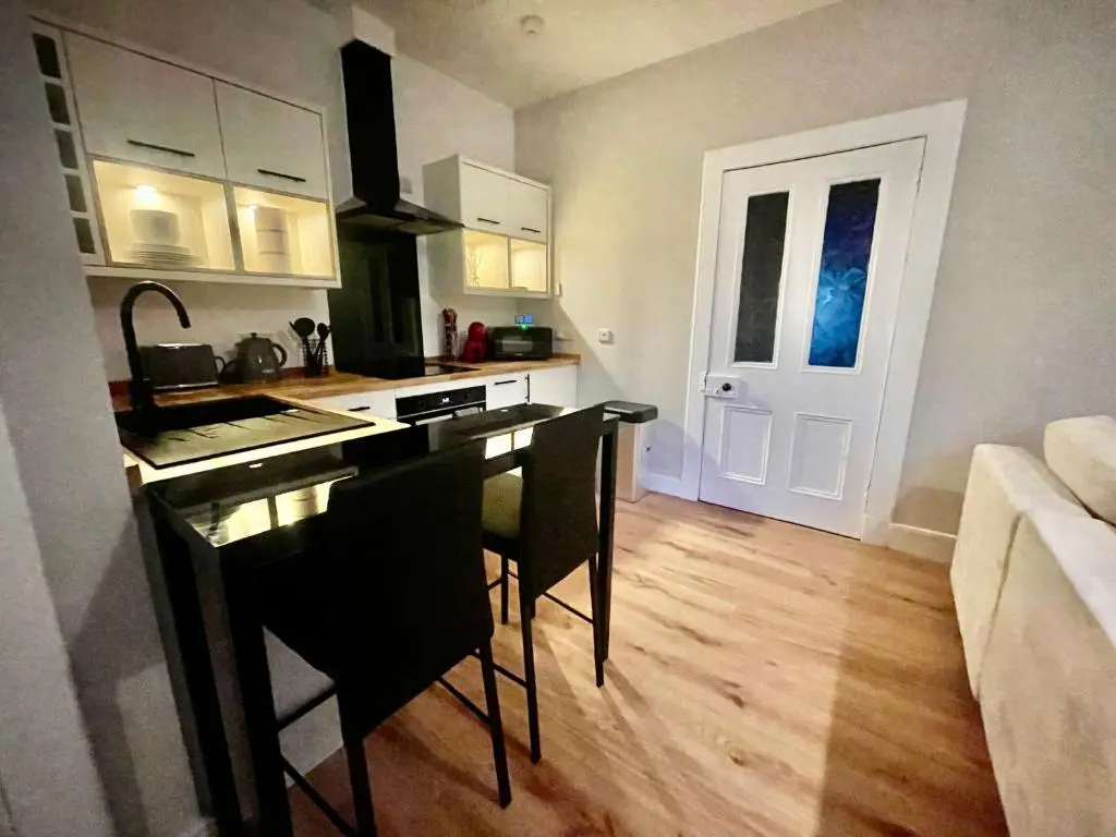 a kitchen with a table and chairs in a room at The Nairn Neuk - Couples Cosy Getaway in Nairn