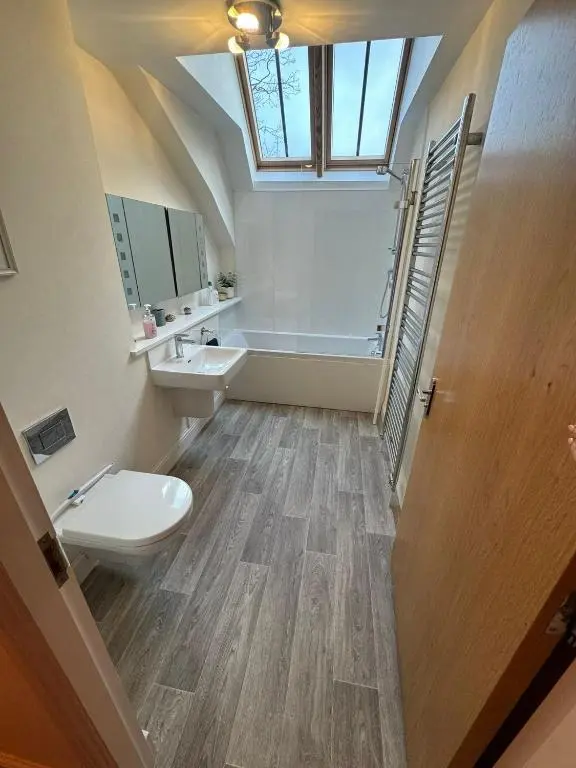 a bathroom with a toilet and a sink and a window at Turfhill House in New Deer