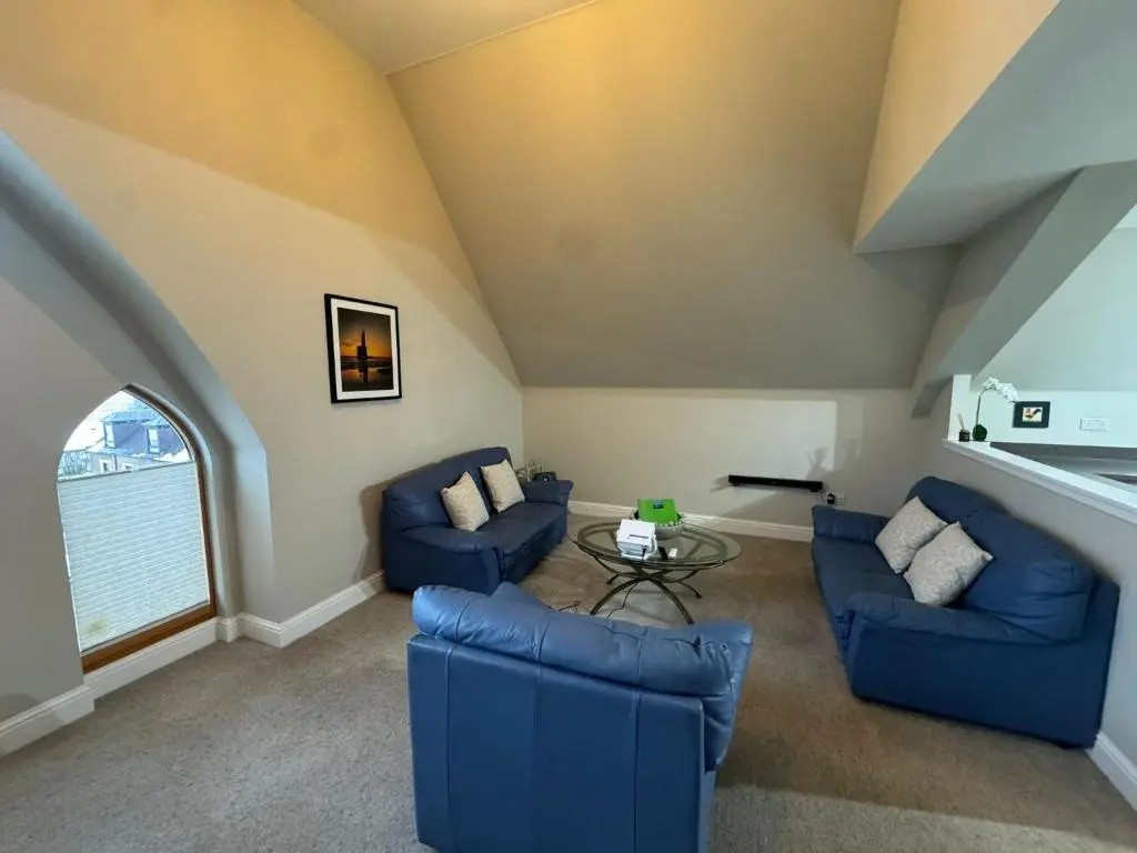 a living room with two blue couches and a table at Turfhill House in New Deer