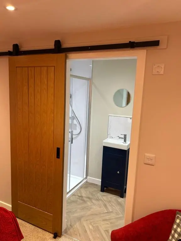 a door leading into a bathroom with a sink at Calsie Cottage, Clatt in Kirktown of Clatt