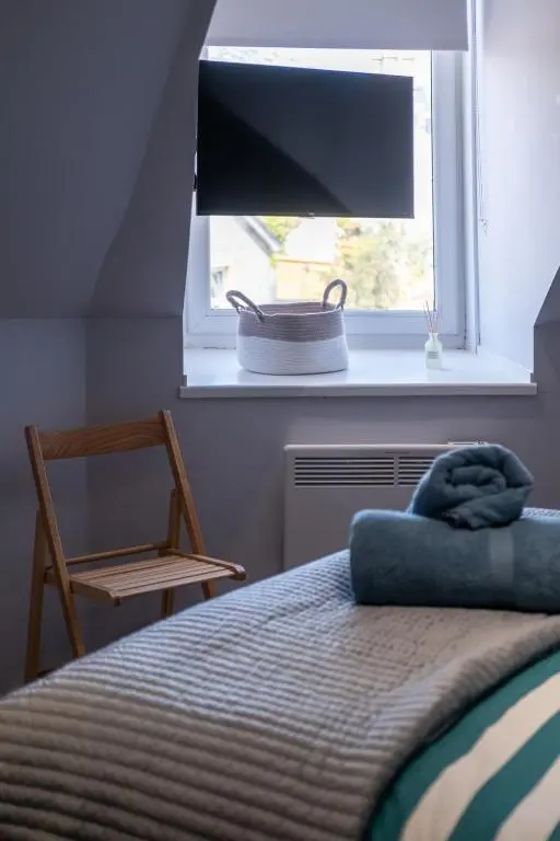 a bedroom with a bed and a window with a television at Charming 2 bed in Aberchirder in Aberchirder