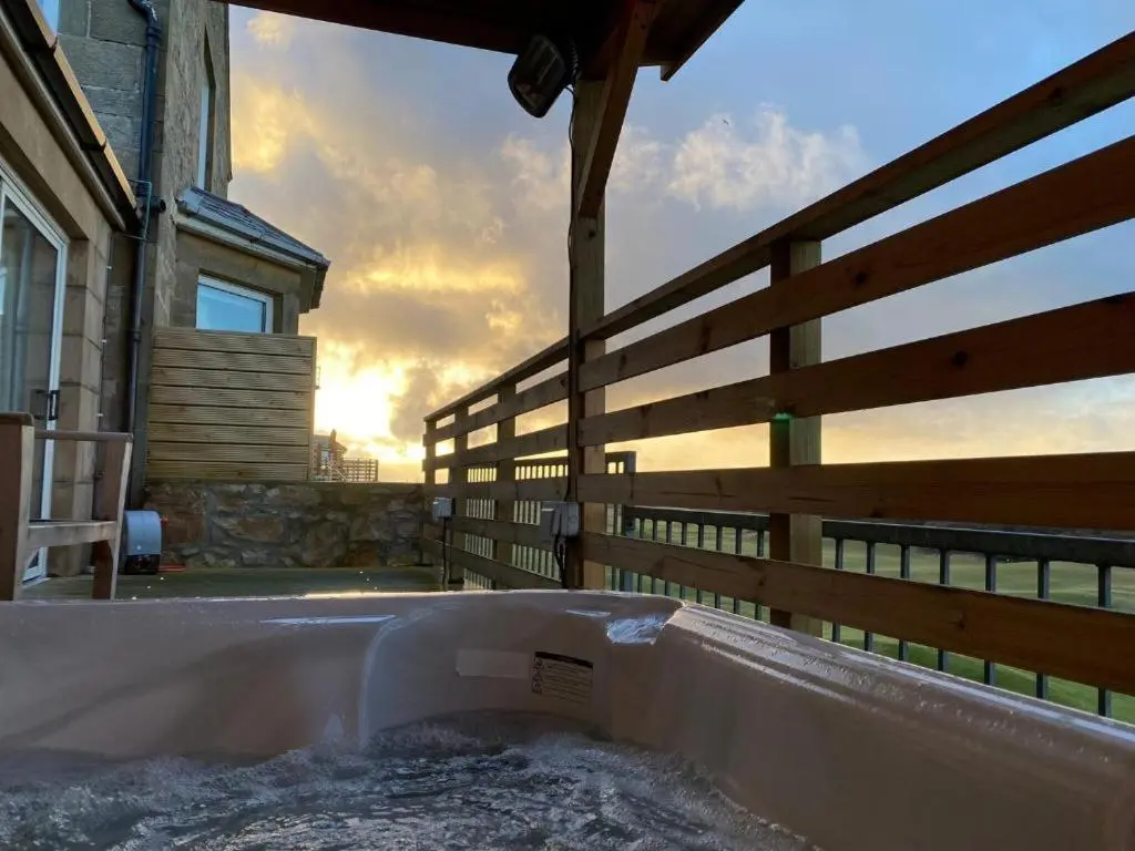 a hot tub outside of a house with a fence at Poseidon's in Lossiemouth