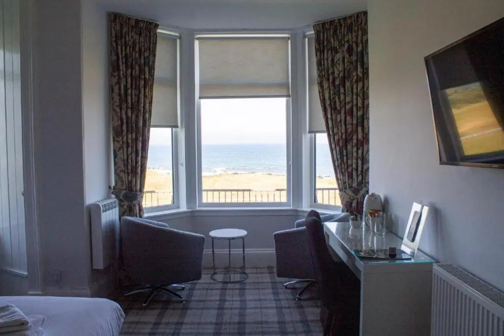 a hotel room with a bedroom with a view of the ocean at Poseidon's in Lossiemouth