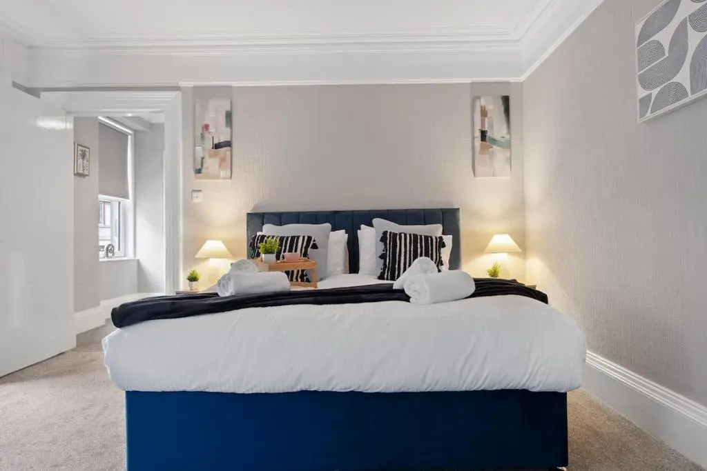 a bedroom with a blue and white bed with two lamps at Leo Apartment - 4 Bedroom Flat in Nairn in Nairn