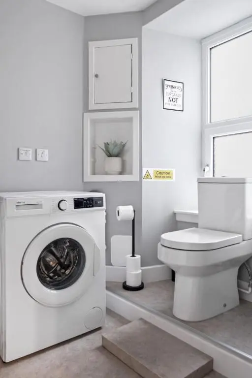 a bathroom with a washing machine and a toilet at Leo Apartment - 4 Bedroom Flat in Nairn in Nairn
