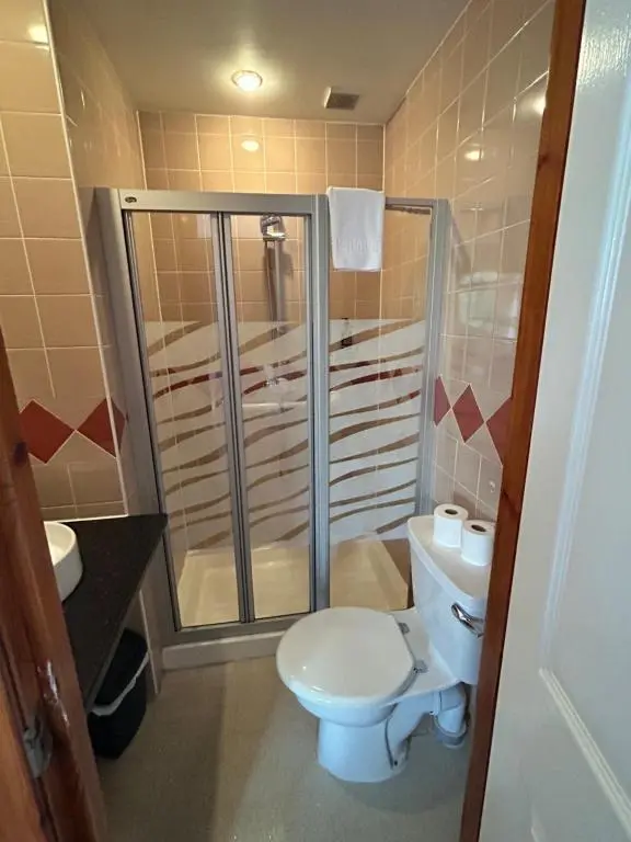 a bathroom with a toilet and a shower at Westend Hotel & Bar in Nairn