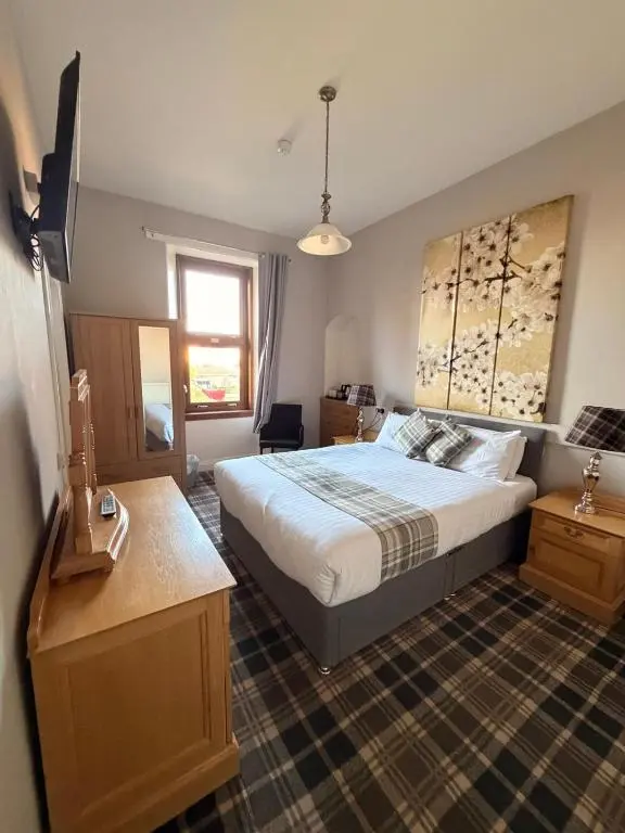 a bedroom with a large bed and a window at Westend Hotel & Bar in Nairn