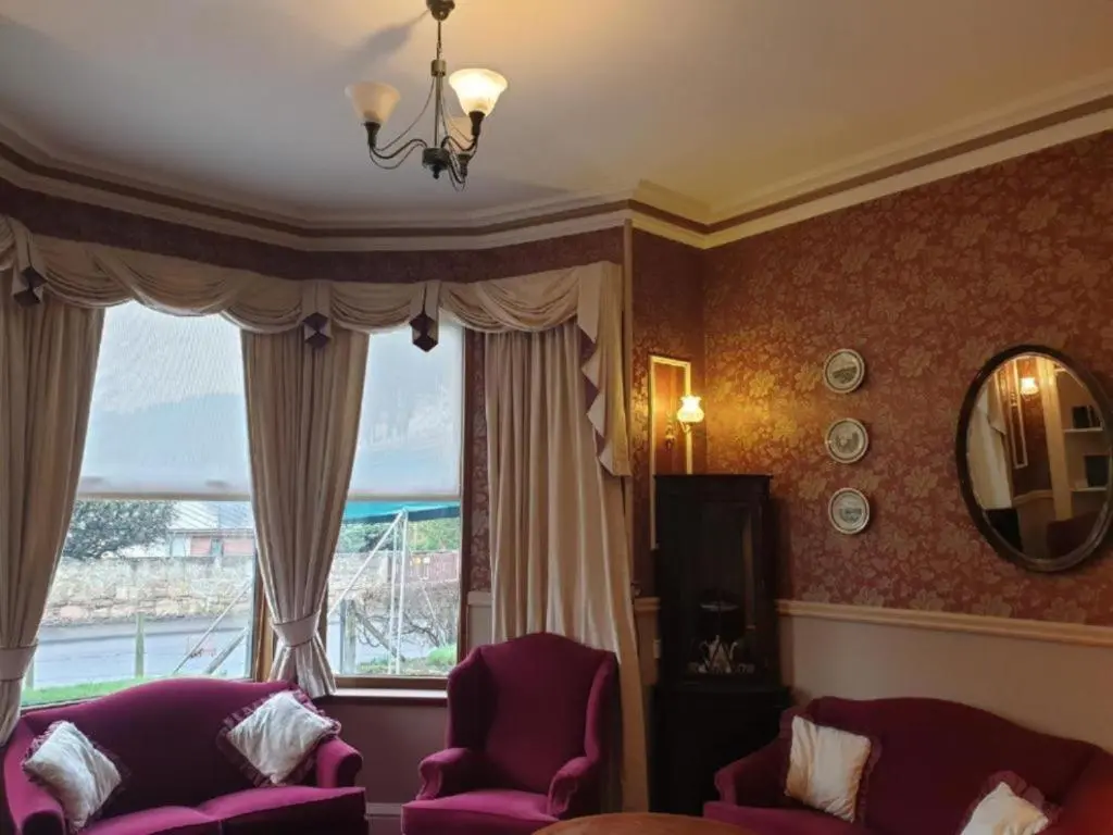 a living room with two chairs and a large window at Westend Hotel & Bar in Nairn