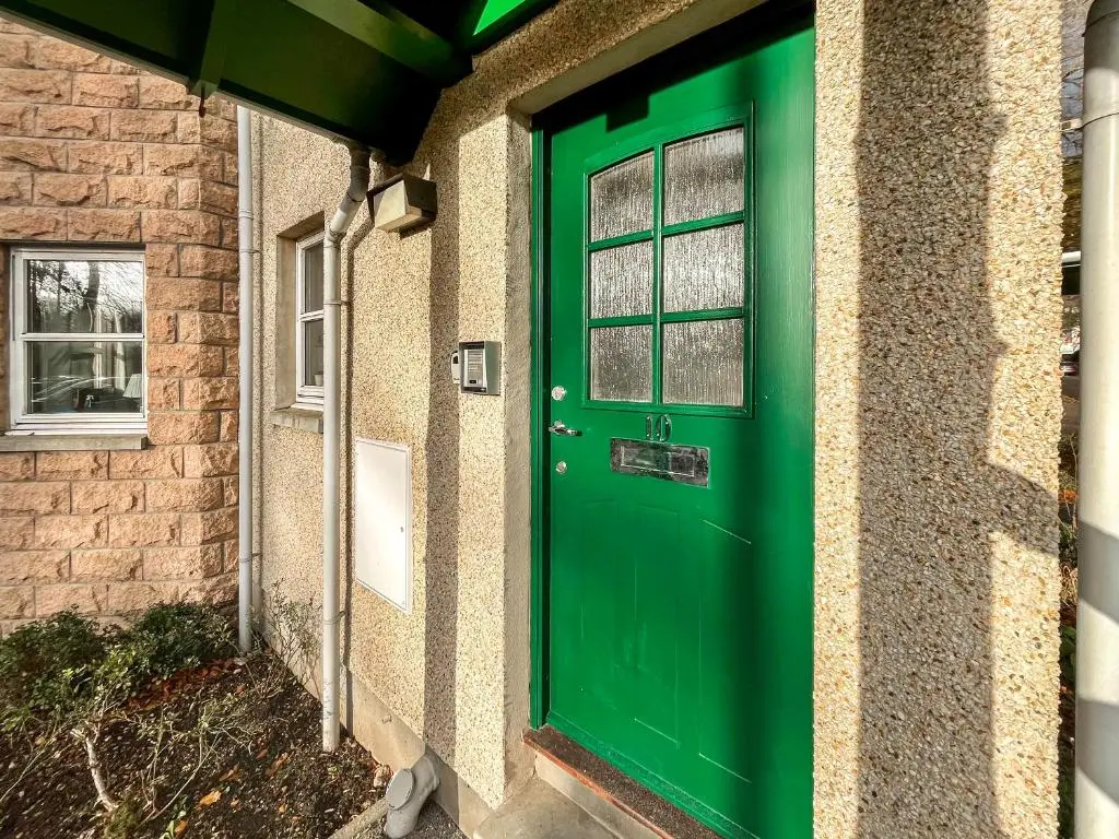 a green door on the side of a house at Dee View Apartment in Banchory