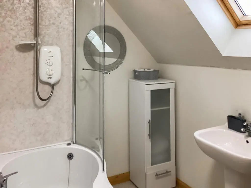 a bathroom with a shower with a toilet and a sink at Mirodon in Brora