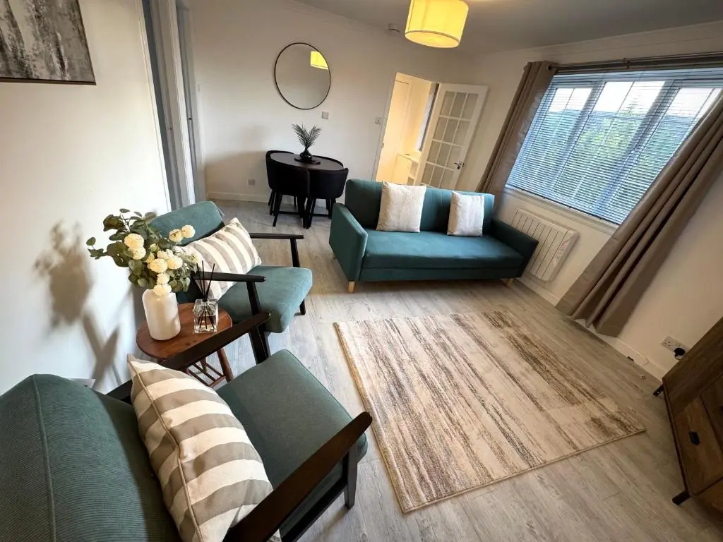 a living room with two couches and a table at Culduthel Court Apartment in Inshes
