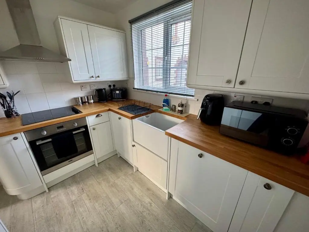 a kitchen with white cabinets and a sink at Culduthel Court Apartment in Inshes