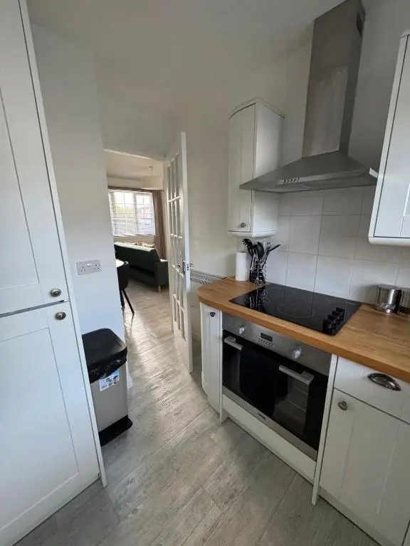 a kitchen with white cabinets and a stove top oven at Culduthel Court Apartment in Inshes