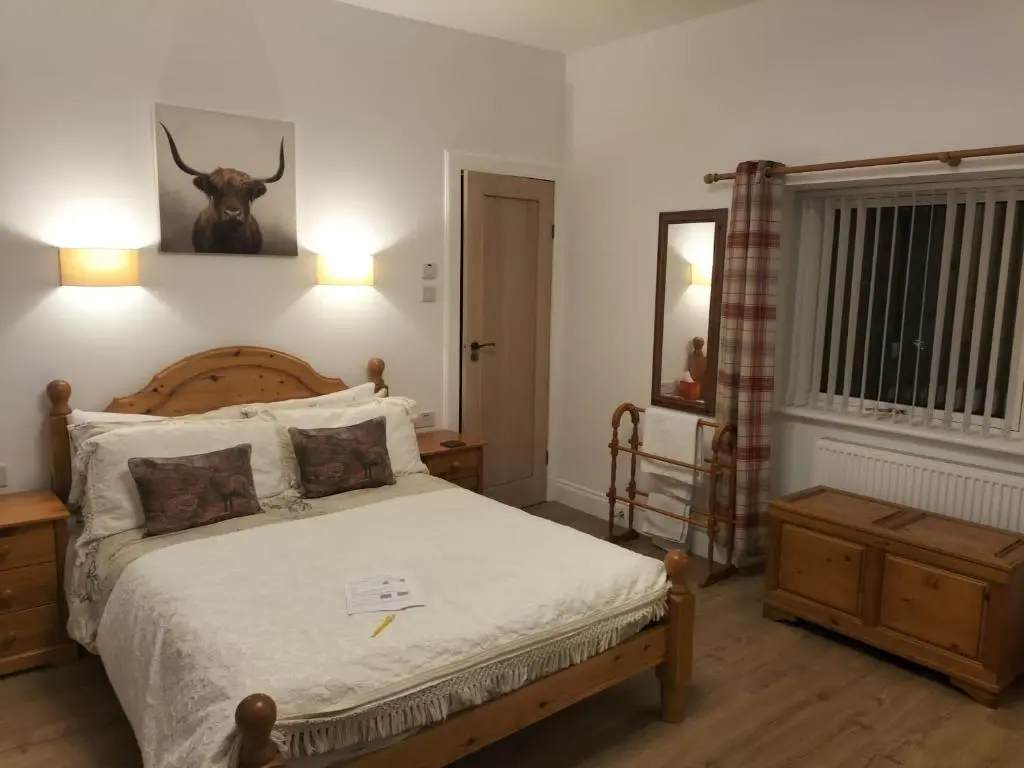 a bedroom with a bed with a deer head on the wall at Atherstone B&B in Inverness