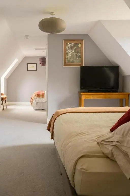 a bedroom with a bed and a flat screen tv at Overscaig House in Lairg