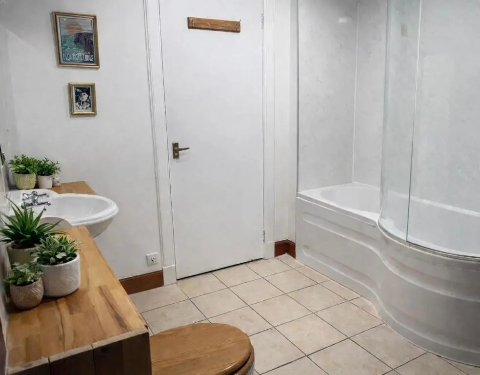 a bathroom with a tub and a toilet and a sink at Overscaig House in Lairg