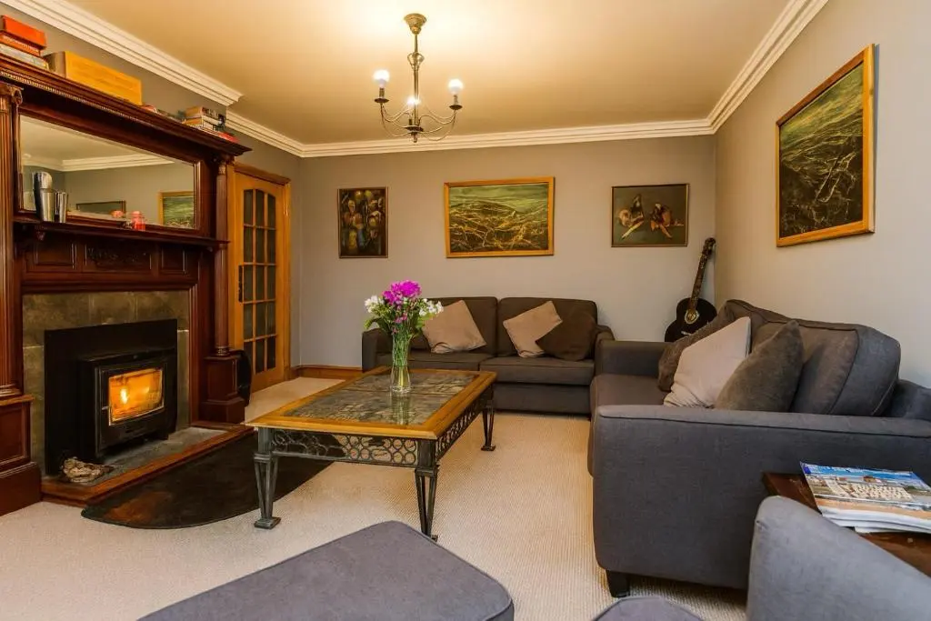 a living room with a couch and a fireplace at Overscaig House - The Annexe in Lairg