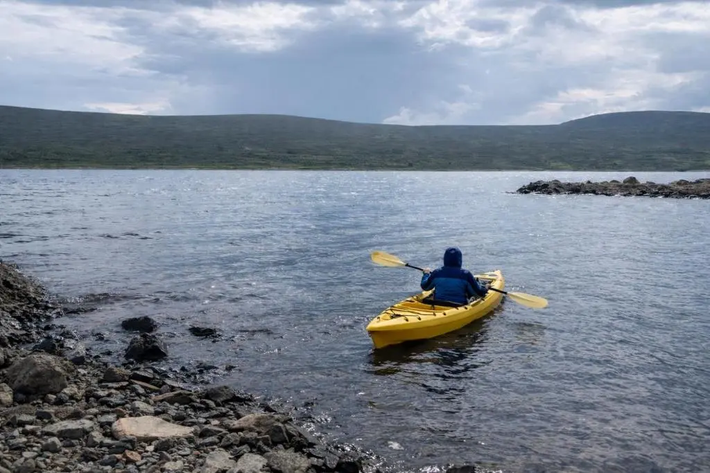 a person in a yellow kayak in the water at Overscaig House - The Annexe in Lairg