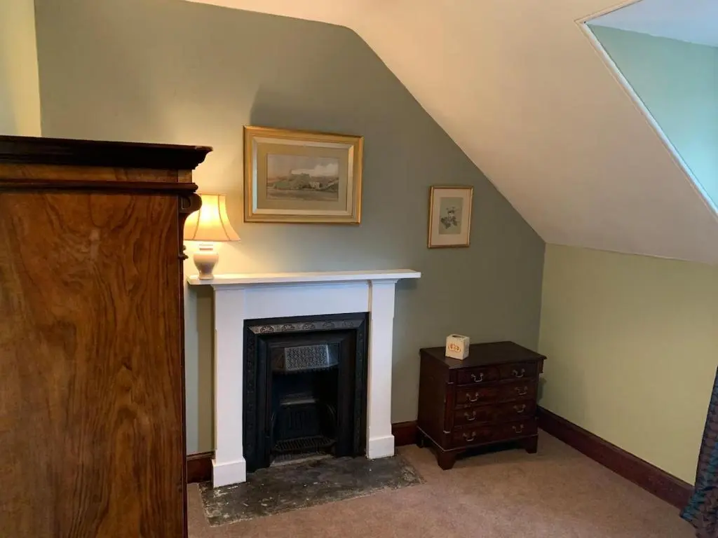 a living room with a fireplace and a table at Glenerne 3 bedroom Cottage in Elgin