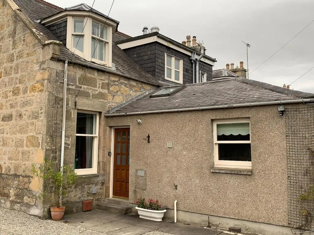 a brick house with a window and a door at Glenerne 3 bedroom Cottage in Elgin
