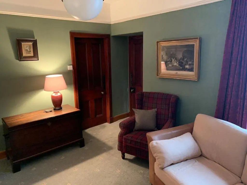 a living room with a couch and a chair at Glenerne 3 bedroom Cottage in Elgin