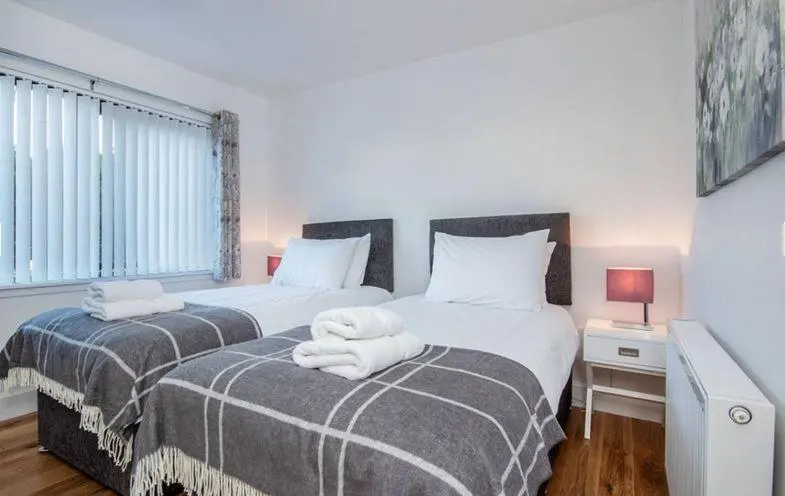 a bedroom with two beds with towels on them at 2 Bedroom Macewen Drive in Inverness
