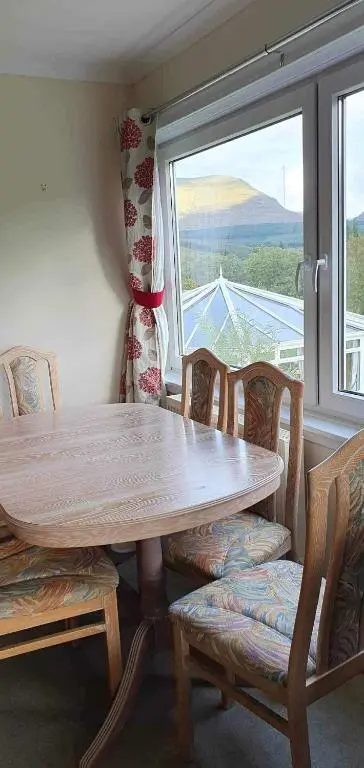 a table and chairs in a room with a window at River View in Garve