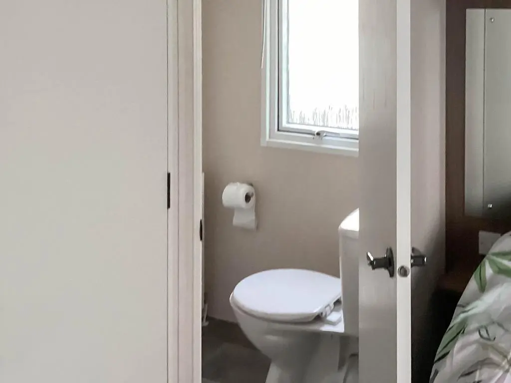 a bathroom with a toilet and a window at A Stone's Throw in Lossiemouth