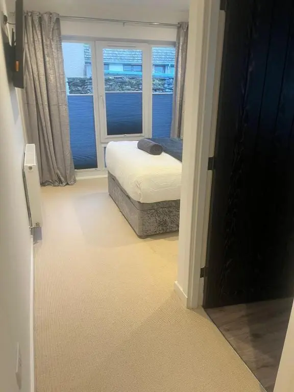 a bedroom with a bed and a window with the ocean at Newly Renovated Luxuary Flat overlooking Wick Bay in Wick