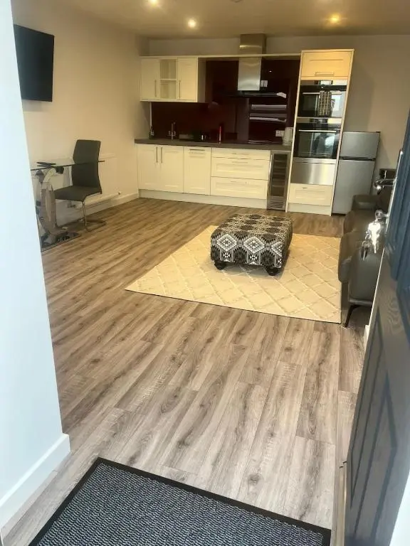 a living room with wooden floors and a kitchen at Newly Renovated Luxuary Flat overlooking Wick Bay in Wick