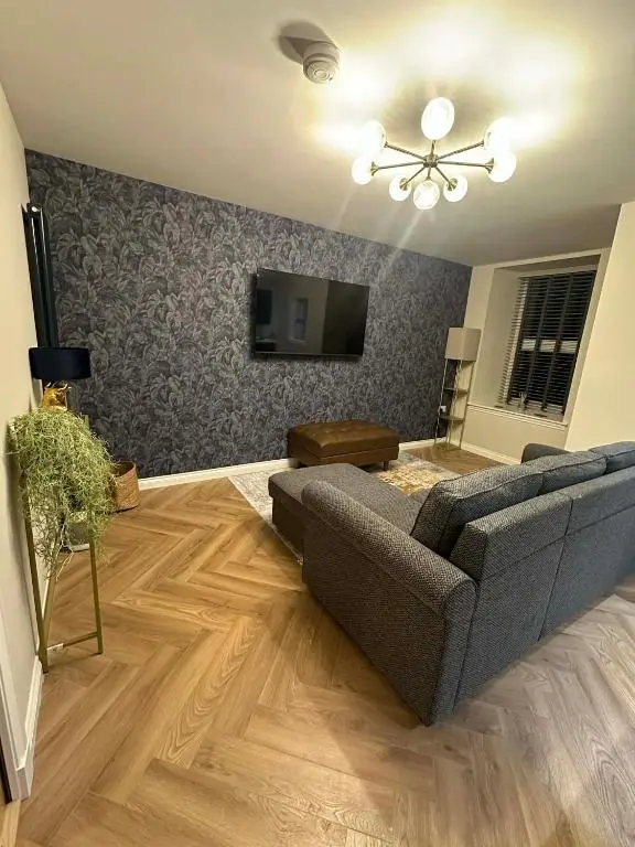 a living room with a couch and a tv at Modern central apartment in Wick