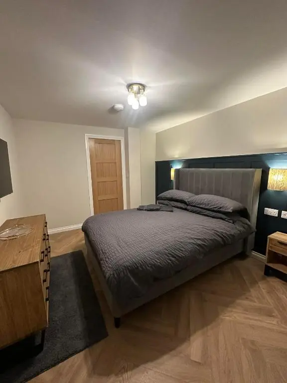 a bedroom with a bed and a wooden table at Modern central apartment in Wick