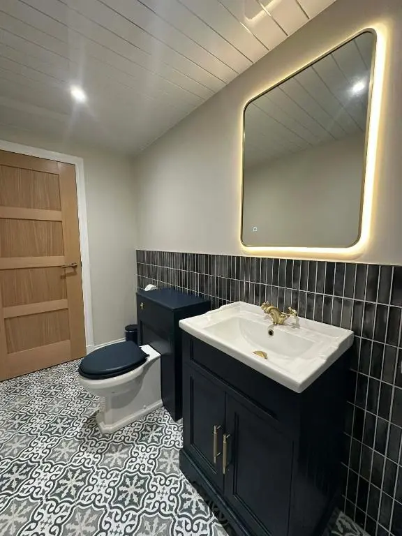 a bathroom with a toilet and a sink and a mirror at Modern central apartment in Wick