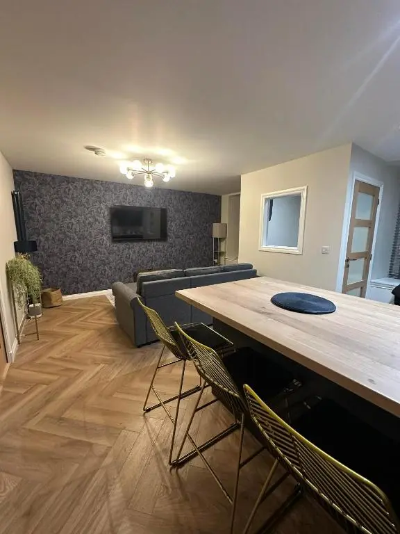 a living room with a table and chairs and a couch at Modern central apartment in Wick
