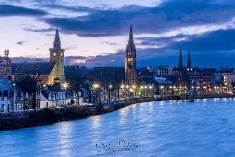 a city at night with a river and buildings at City Centre 3 Bedroom house with parking in Dalneigh