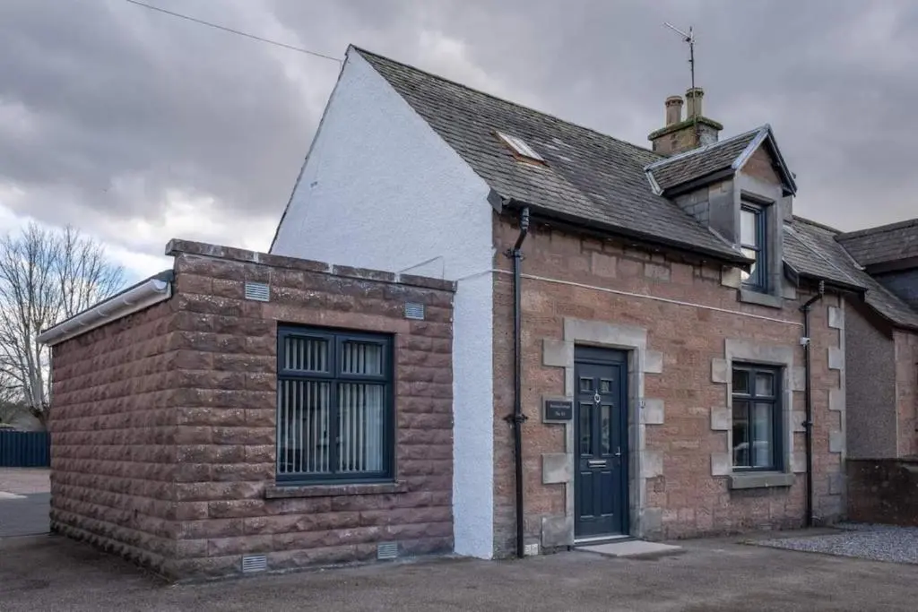 an old brick building with a black door at City Centre 3 Bedroom house with parking in Dalneigh